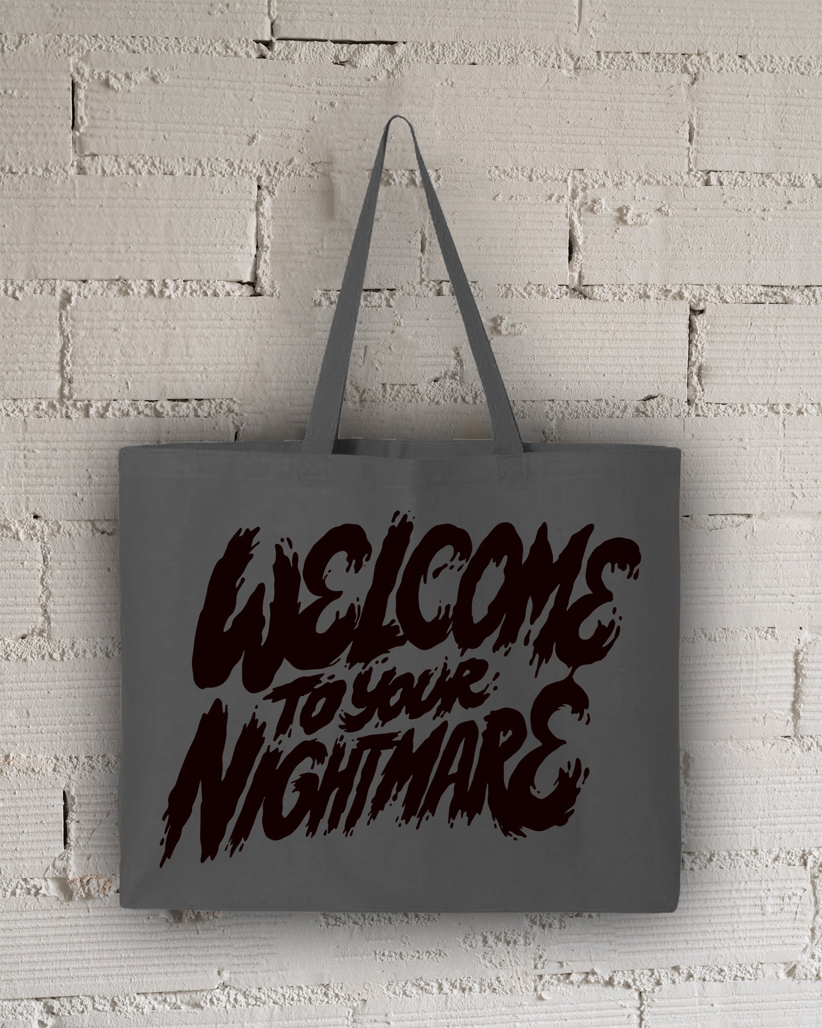 Charcoal tote bag featuring black text that reads Welcome to Your Nightmare in a horror-style font.
